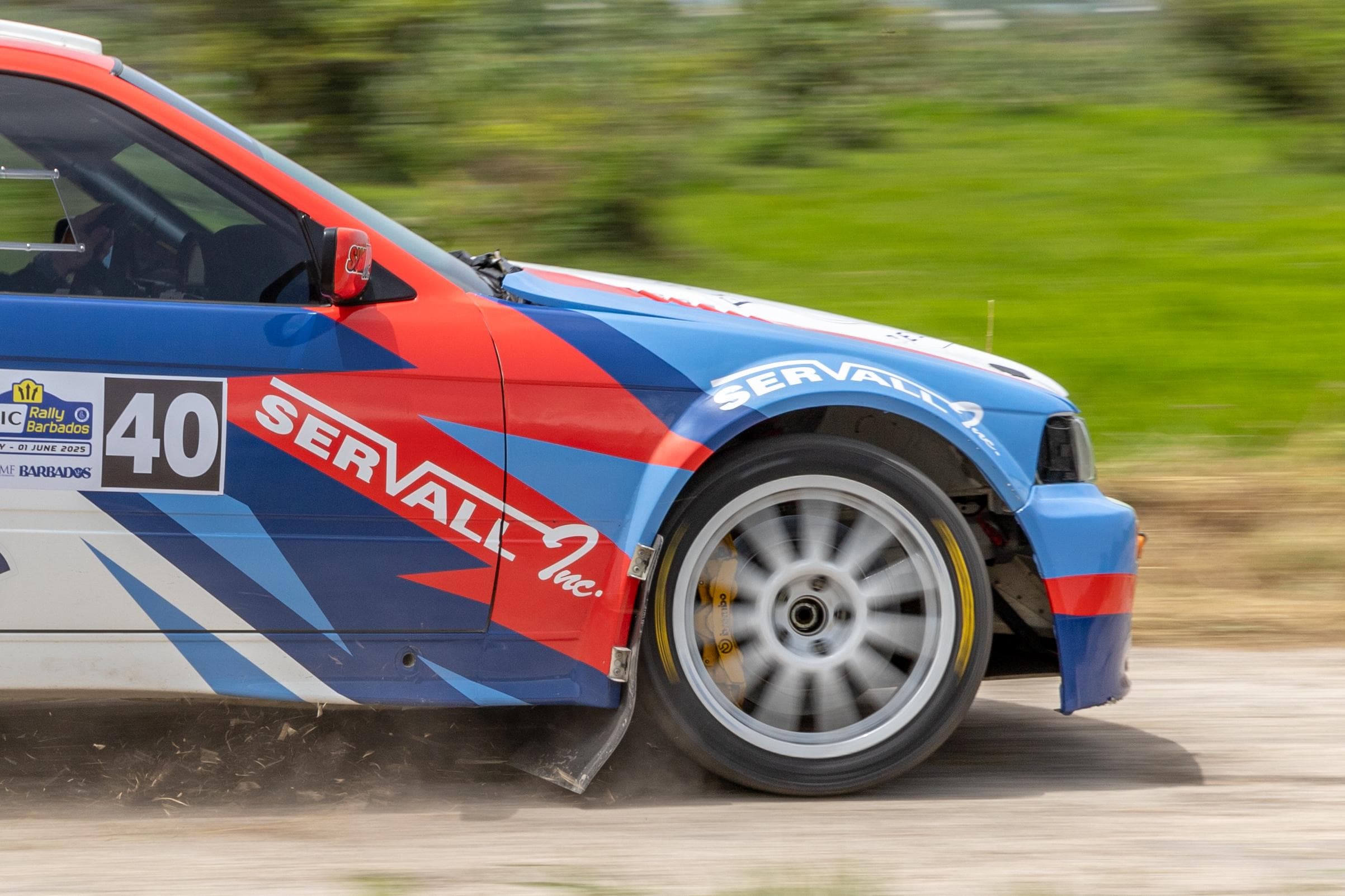 Rally car taking a sharp hairpin turn on dirt road